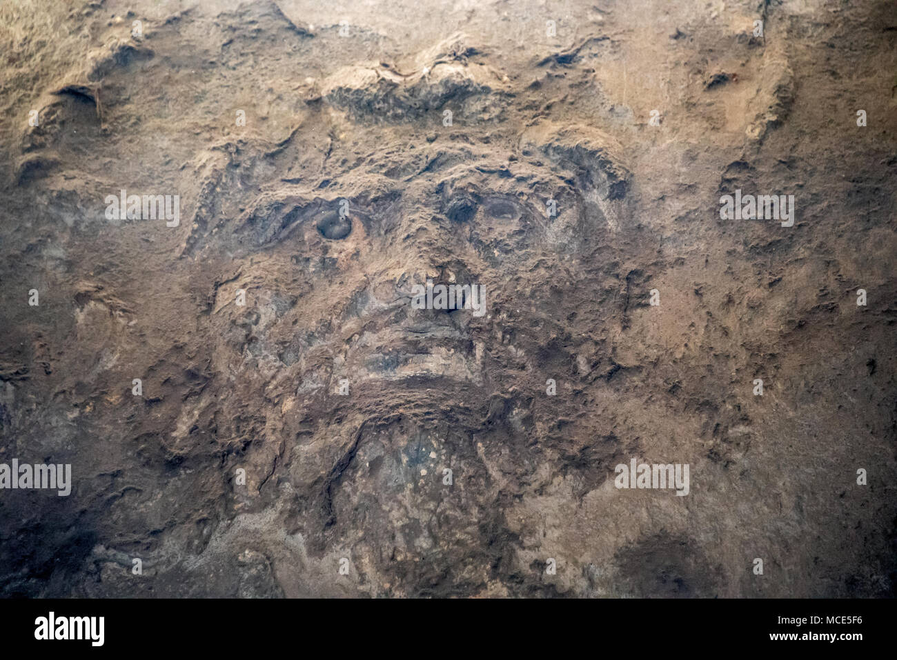 Face of an ancient god carved into wall of a Men's Bath at Pompeii, placed high above the "cold room" just beneath the open skylight. Stock Photo