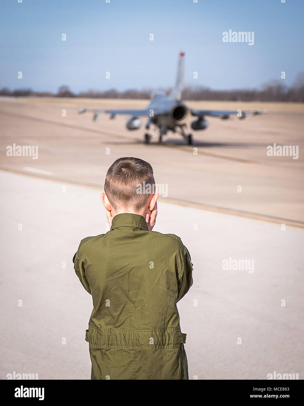 Andrew 'Gunner' Jolly, Pilot For A Day, 138th Fighter Wing's newest Top Gun, watches jets taxi onto runway at Tulsa Air National Guard Base, Oklahoma, Feb 27, 2018. The Pilot For A Day program allows children with potentially life threatening illnesses a chance to experience a day in the life of a Fighter Pilot. (U.S. Air National Guard Photo by Master Sgt. CT Michael/Released). Stock Photo