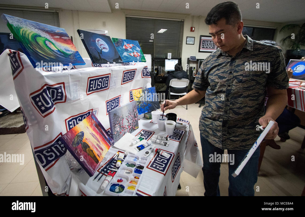 180223-N-AE545-0155 SASEBO, Japan (Feb. 23, 2018) Eric Jovellanos, a self-taught artist, completes a painting during paint night at USO Sasebo. Jovellanos began painting after his 26 year career with the U.S. Navy as a way to fill his free time after his children left for college. He began teaching at paint night to help other DoD community members overseas deal with stress and being away from family. (U.S. Navy photo by Mass Communication Specialist 2nd Class Gabriel B. Kotico/Released) Stock Photo