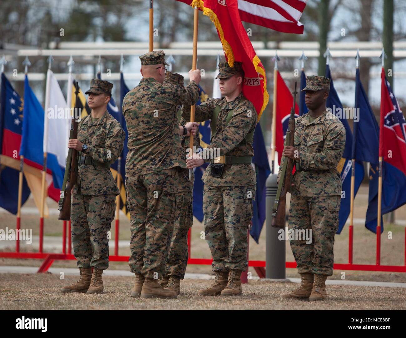 U.S. Navy Field Medical Training Battalion-East (FMTB-E) Command Master Chief Matthew Deschamps is passed the unit colors during the FMTB-E change of command ceremony at Camp Johnson, N.C., Jan. 9, 2018. The change of command ceremony is a time-honered tradition in which one commander reliquishes command to another. (U.S. Marine Corps photo by Lance Corporal Tyler Pender) Stock Photo