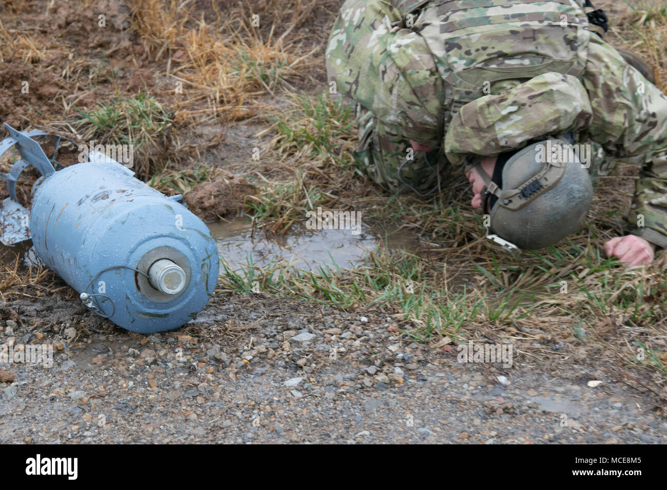 Sgt. Josh Wilson, an explosive ordnance disposal team leader with 49th Ordnance Company (Explosive Ordnance Disposal), 184th Ordnance Battalion (EOD), 52nd Ordnance Group (EOD), 20th Chemical, Biological, Radiological, Nuclear and high-yield Explosive Command, examines a simulated round for additional triggers on the training areas of Fort Campbell, Ky., Feb. 22, 2018. This simulation was part of multi-echelon training exercise for the group and included a validation exercise for the company for its upcoming deployment to Southwest Asia. (U.S. Army photo by Staff Sgt. Adam Hinman) Stock Photo