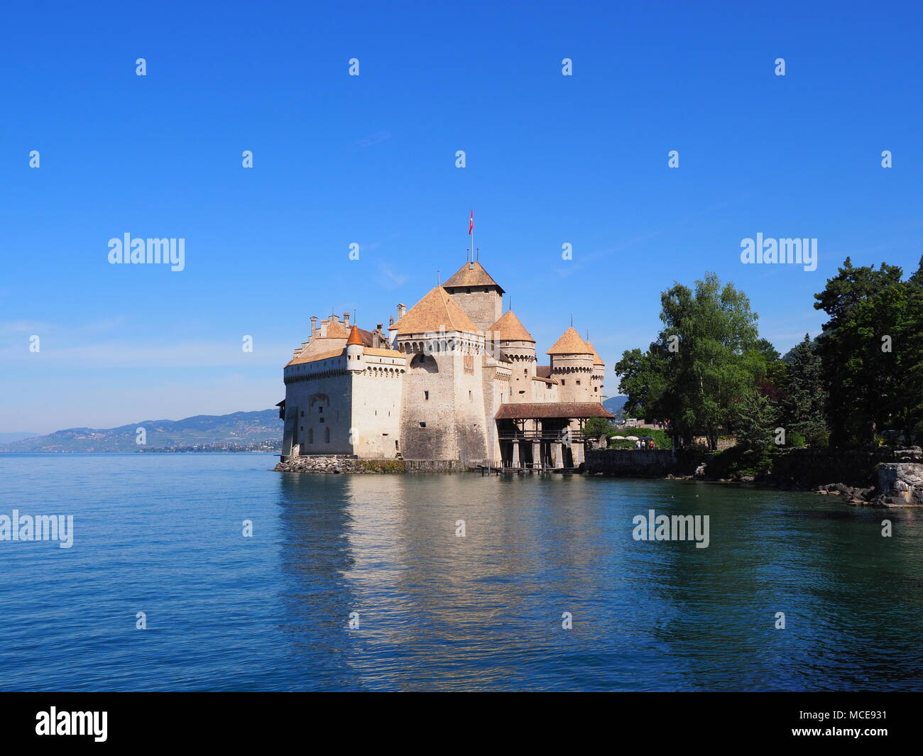View of medieval Chateau de Chillon castle at Lake Geneva in Montreux city, Canton of Vaud in Switzerland, landscapes of alpine Lac Leman, clear blue  Stock Photo
