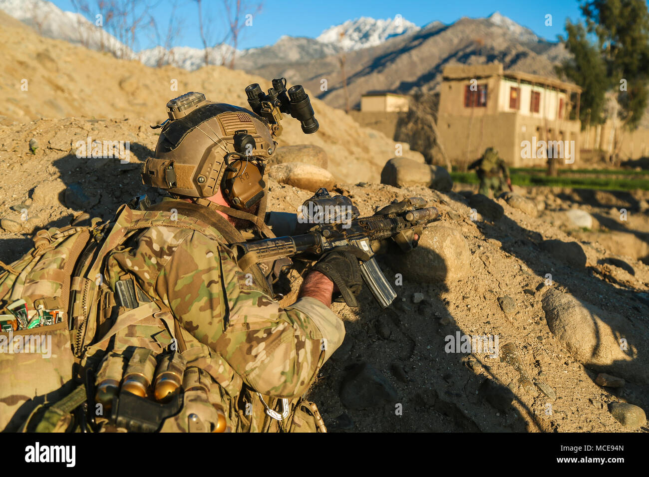 A U.S. Army Special Forces Soldier, attached to Special Operations Task Force-Afghanistan, provides rear security as an Afghan Commando assault force raids a compound of interest during an operation in the Alingar district, Laghman province, Afghanistan, Feb. 18, 2018. The purpose of this operation was to destroy the command and control element of the Taliban in the area and force the remaining forces out of the valley. (U.S. Army photo by Sgt. Connor Mendez) Stock Photo