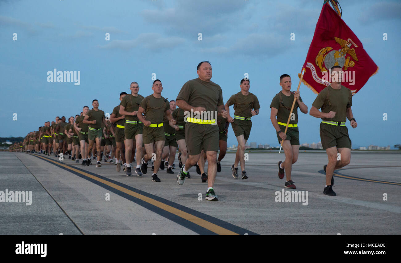 Marines with Marine Tactical Air Command Squadron 18, Marine Air Control Group 18, 1st Marine Aircraft Wing, participate in a motivational run at Marine Corps Air Station Futenma, Okinawa, Japan, April 10, 2018. Over 1,000 Marines were in attendance to run 3 miles around the air station flight line. 1st MAW is the aviation combat element of III Marine Expeditionary Force. Its mission is to conduct air operations in support of the Fleet Marine Forces Pacific. (U.S. Marine Corps photo by Sgt. Natalie Dillon) Stock Photo