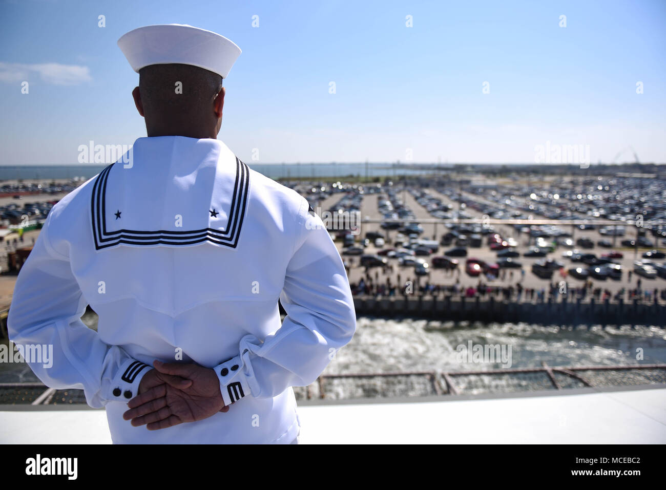 180411-N-NQ487-222  NORFOLK (April 11, 2018) Personnel Specialist 3rd Class Anthony White mans the rails aboard the aircraft carrier USS Harry S. Truman (CVN 75) during the ship's departure from homeport. Harry S. Truman is underway as the flagship for the Harry S. Truman Carrier Strike Group which includes; guided-missile cruiser USS Normandy (CG-60), and guided-missile destroyers USS Arleigh Burke (DDG-51), USS Bulkeley (DDG-84), USS Farragut (DDG-99), USS Forrest Sherman (DDG-98), USS The Sullivans (DDG-68), USS Winston S. Churchill (DDG-81) for a regularly scheduled deployment. (U.S. Navy  Stock Photo