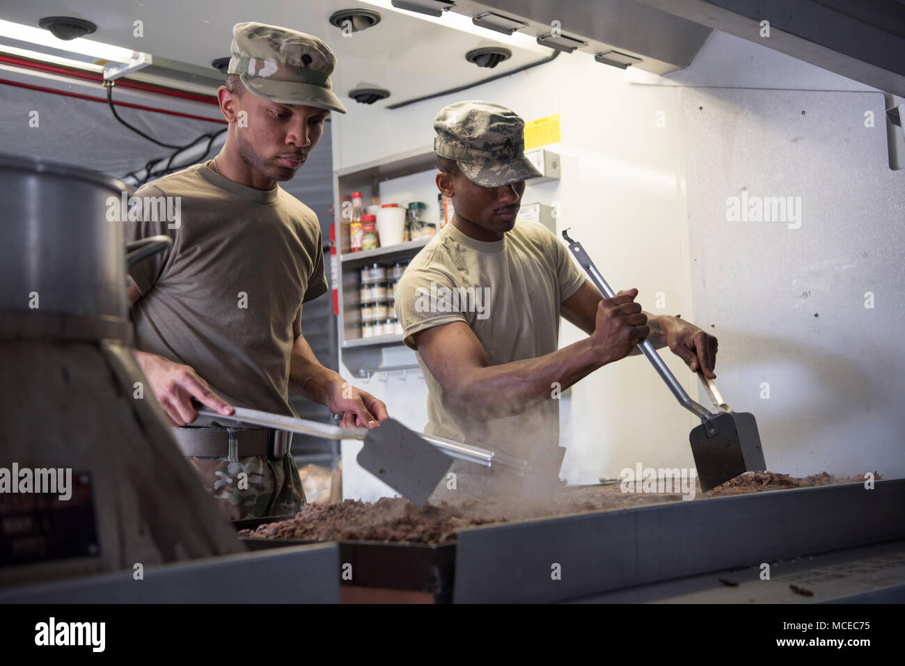 Spc. Joshua Richardson, culinary specialist, Headquarters and Headquarters Company, 113th Engineer Battalion, Indiana Army National Guard, and Sgt. Raymond Elliott, Bravo Co., 218th Brigade Support Battalion, South Carolina Army National Guard, prepare dinner for Soldiers at Jennings County Fairgrounds, North Vernon, Indiana, during Vibrant Response 2018, April 11. U.S. Army North conducts Exercise Vibrant Response annually as part of its mission to train the nation's military CBRN response capability.(U.S. Army photo by Staff Sgt. Jerry Boffen, 108th Public Affairs Detachment) Stock Photo