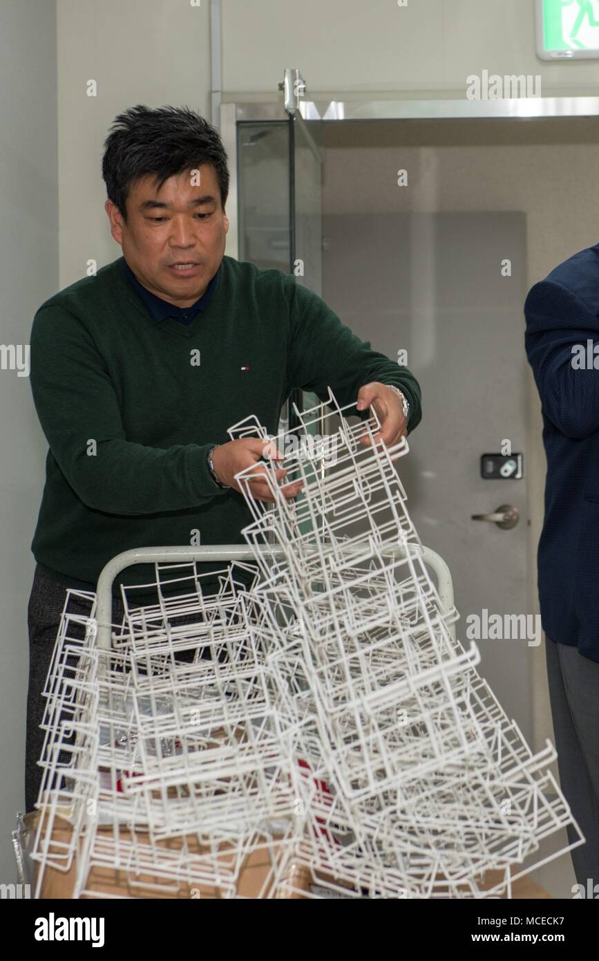 180412-N-TB148-007 BUSAN, Republic of Korea (April 12, 2018) Mr. Chae, Keun Shik, a housing director for Busan Family Support Center (BFSC), separates pamphlet racks at the new BFSC office in Busan. This is the first opening of a family support center since Commander, U.S. Naval Forces Korea moves to the area in Feb. 2016. (U.S. Navy photo by Mass Communication Specialist Seaman William Carlisle) (U.S. Navy photo by Mass Communication Specialist Seaman William Carlisle) Stock Photo