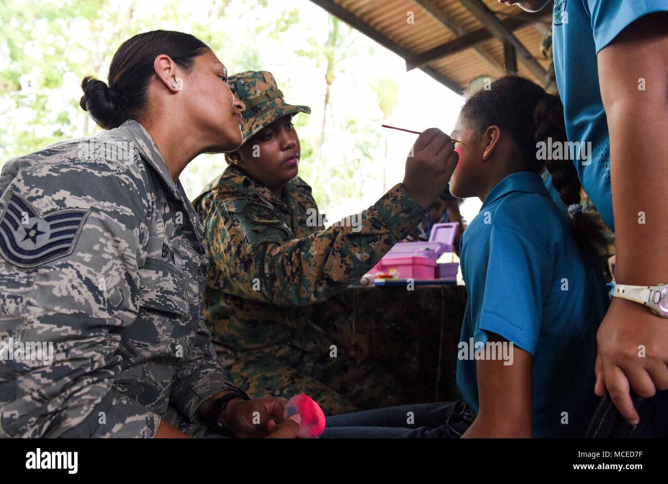 U.S. Air Force Tech. Sgt. Claudia Bryant, 346th Air Expeditionary Group security forces member, deployed from Tucson, Arizona, paints the face of a guest during the opening ceremony of Exercise New Horizons 2018, April 11, 2018 in Meteti, Panama. Exercise New Horizons is a joint training exercise where all branches of the U.S. military conduct training in civil engineer, medical and support services while benefiting the local community. During the exercise, U.S. military members will build three schools, one community center and a women’s health ward in the Meteti area. They will also work clo Stock Photo