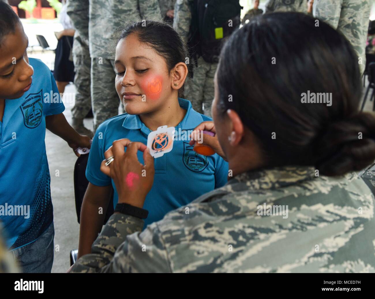 U.S. Air Force Tech. Sgt. Claudia Bryant, 346th Air Expeditionary Group security forces member, deployed from Tucson, Arizona, paints the face of a guest during the opening ceremony of Exercise New Horizons 2018, April 11, 2018 in Meteti, Panama. Exercise New Horizons is a joint training exercise where all branches of the U.S. military conduct training in civil engineer, medical and support services while benefiting the local community. During the exercise, U.S. military members will build three schools, one community center and a women’s health ward in the Meteti area. They will also work clo Stock Photo