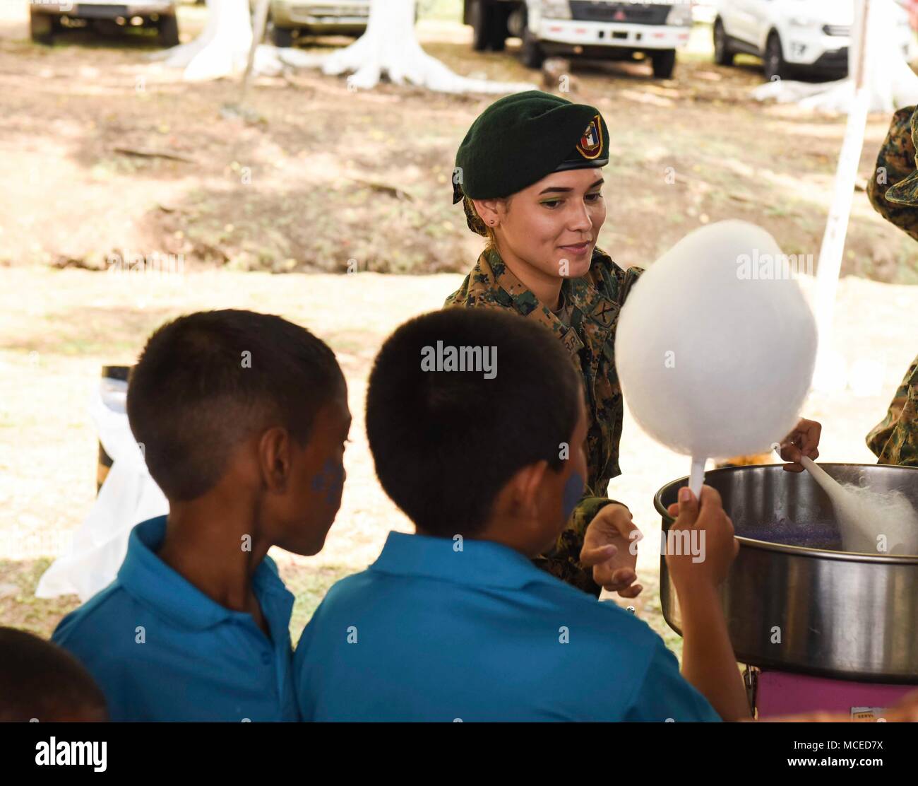 A member of the Panamanian National Border Service, known as SENAFRONT, passes cotton candy to children during the opening ceremony of Exercise New Horizons 2018, April 11, 2018, in Meteti, Panama. Exercise New Horizons is a joint-service operation, focused on enhancing relations with partner nations, providing aid to local communities and providing training U.S. military members. During the exercise, U.S. military members will build three schools, one community center and a women’s health ward in the Meteti area. They will also work closely with Panamanian health providers bringing medical ai Stock Photo