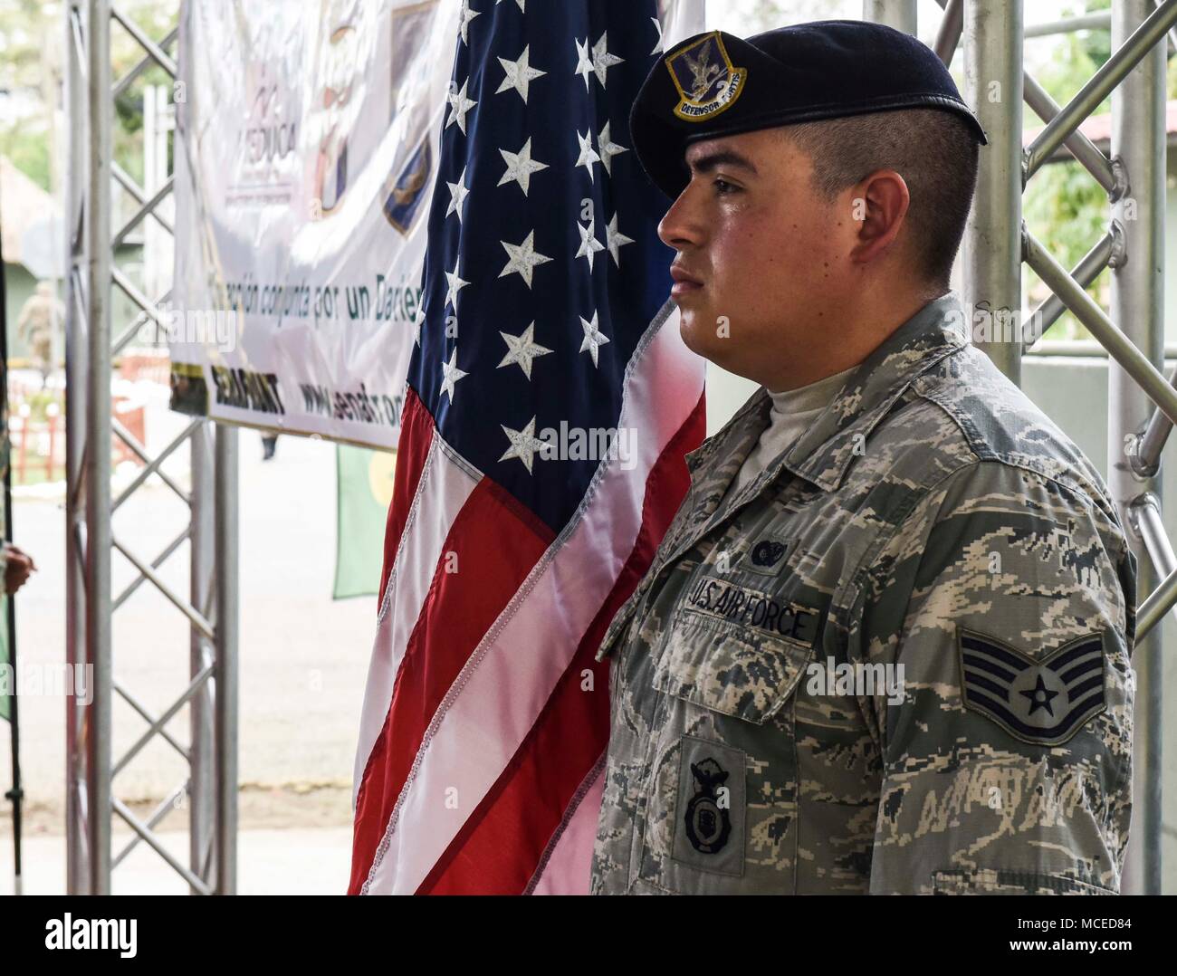 U.S. Air Force Staff Sgt. Ruben Virgen, 346th Air Expeditionary Group security forces member, deployed from Tucson, Ariz., stands next to a U.S. flag during the opening ceremony of Exercise New Horizons 2018, April 11, 2018 in Meteti, Panama. Exercise New Horizons is a joint-service training exercise, focused on enhancing relations with partner nations and providing aid to local communities while providing training U.S. military members. During the exercise, U.S. military members will build three schools, one community center and a women’s health ward in the Meteti area. They will also work cl Stock Photo