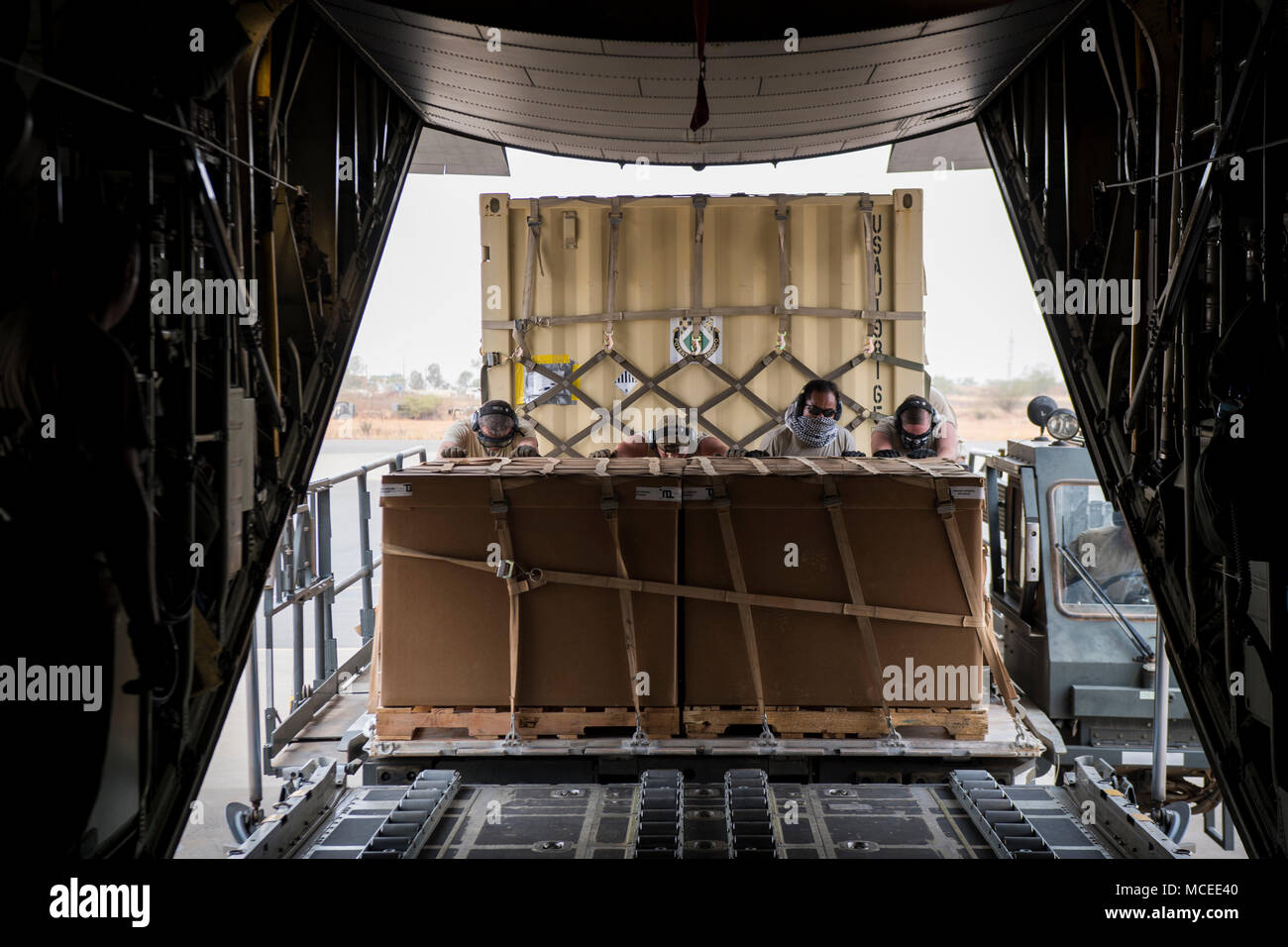 Airmen from the West Virginia Air National Guard move cargo into a C-130H Hercules April 10, 2018 at Diori Hamani International Airport, Niger. Approximately 1,900 service members from more than 20 African and western partner nations are participating in Flintlock 2018 at multiple locations in Niger, Burkina Faso, and Senegal. Flintlock is an annual, African-led, integrated military and law enforcement exercise that has strengthened key partner nation forces throughout North and West Africa as well as western Special Operations Forces since 2005.  (U.S. Air Force photo/Senior Airman Clayton Cu Stock Photo