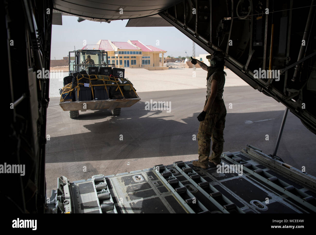 A loadmaster from the West Virginia Air National Guard waves off a forklift April 11, 2018, at Diori Hamani International Airport, Niger. Approximately 1,900 service members from more than 20 African and western partner nations are participating in Flintlock 2018 at multiple locations in Niger, Burkina Faso, and Senegal. Flintlock is an annual, African-led, integrated military and law enforcement exercise that has strengthened key partner nation forces throughout North and West Africa as well as western Special Operations Forces since 2005.  (U.S. Air Force photo/Senior Airman Clayton Cupit) Stock Photo