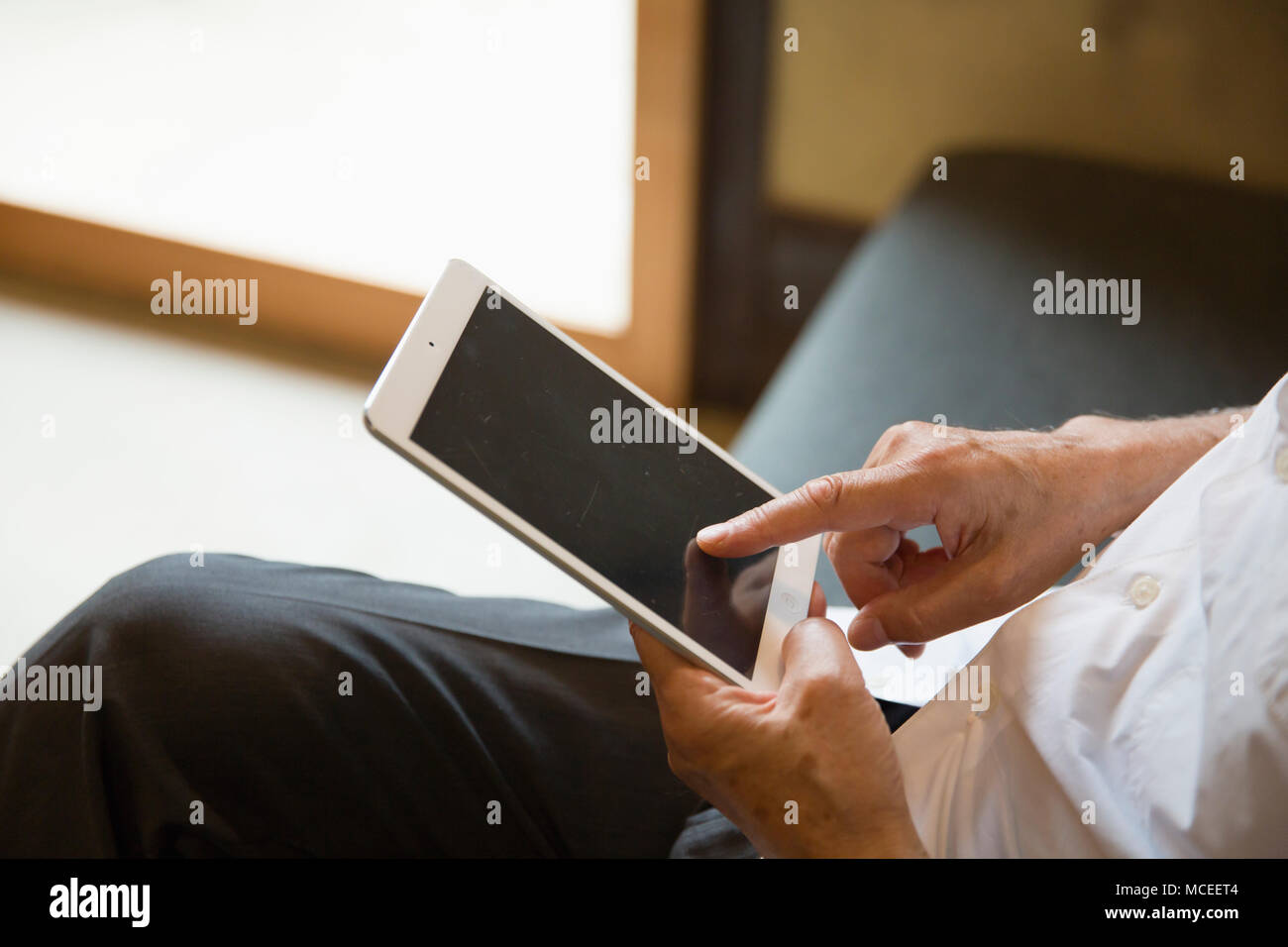 Senior man hands using tablet PC Stock Photo