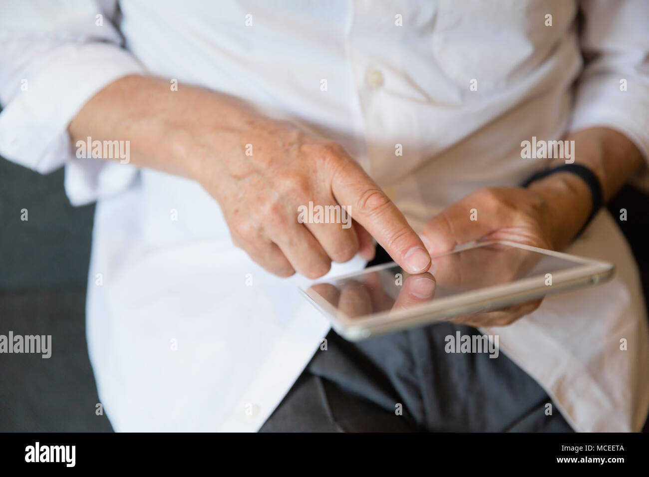 Senior man hands using tablet PC Stock Photo
