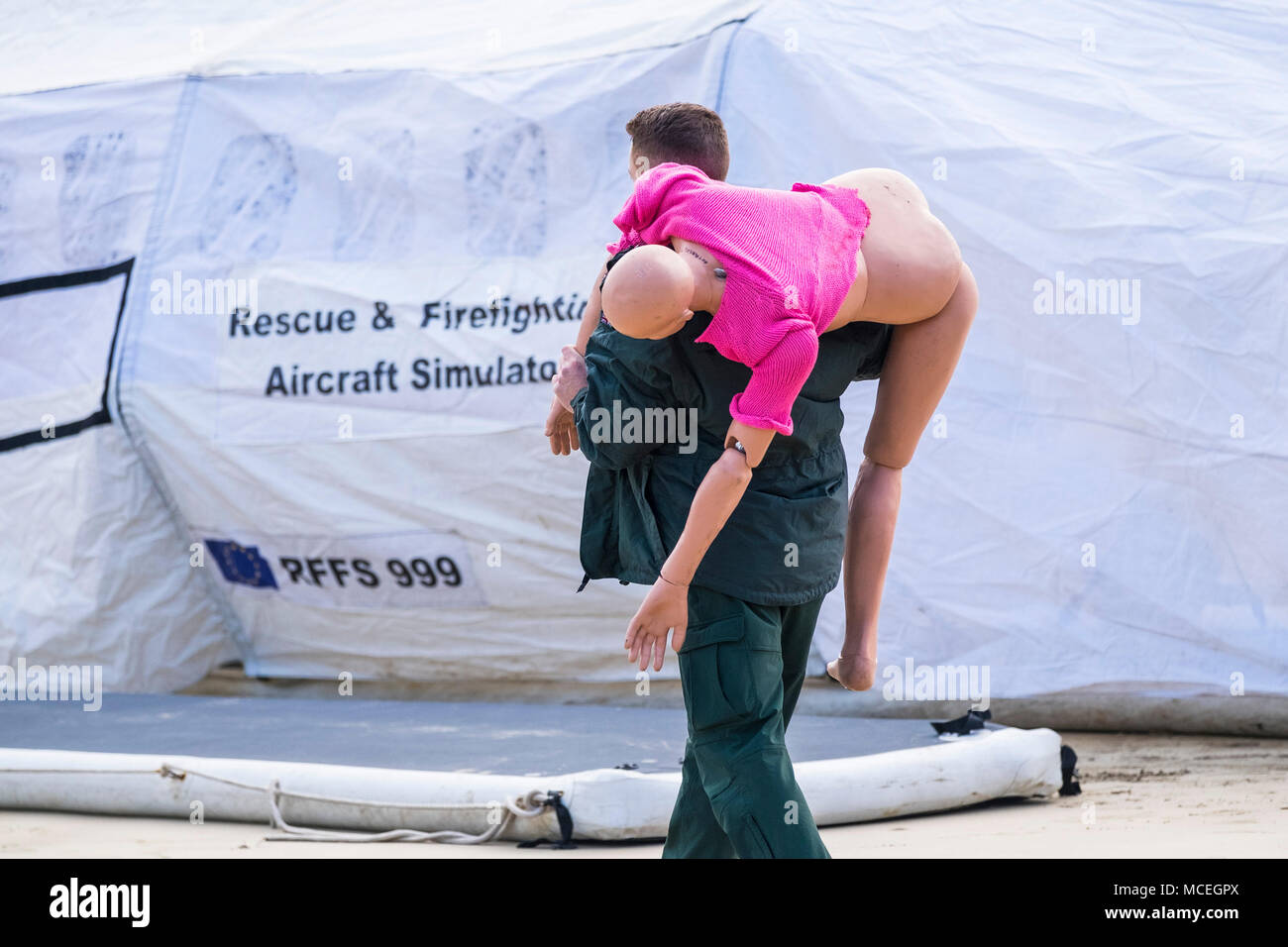 A paramedic carrying a mannequin in preparation for participating in a GMICE (Good Medicine in Challenging Environments) major incident exercise in Ne Stock Photo