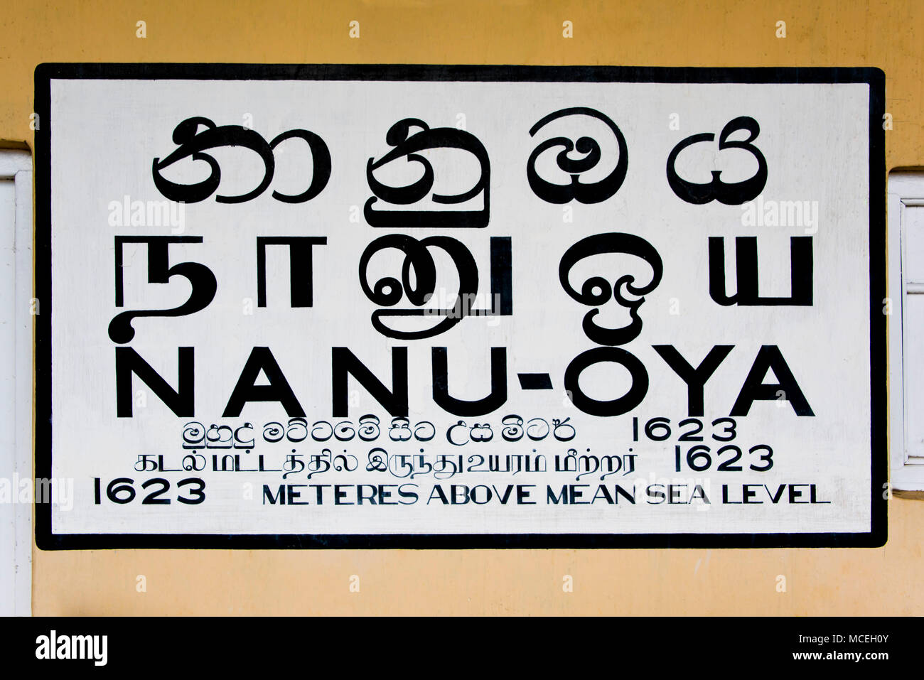 Horizontal view of the handpainted sign at Nanu-oya Train Station in the highlands of Sri Lanka. Stock Photo