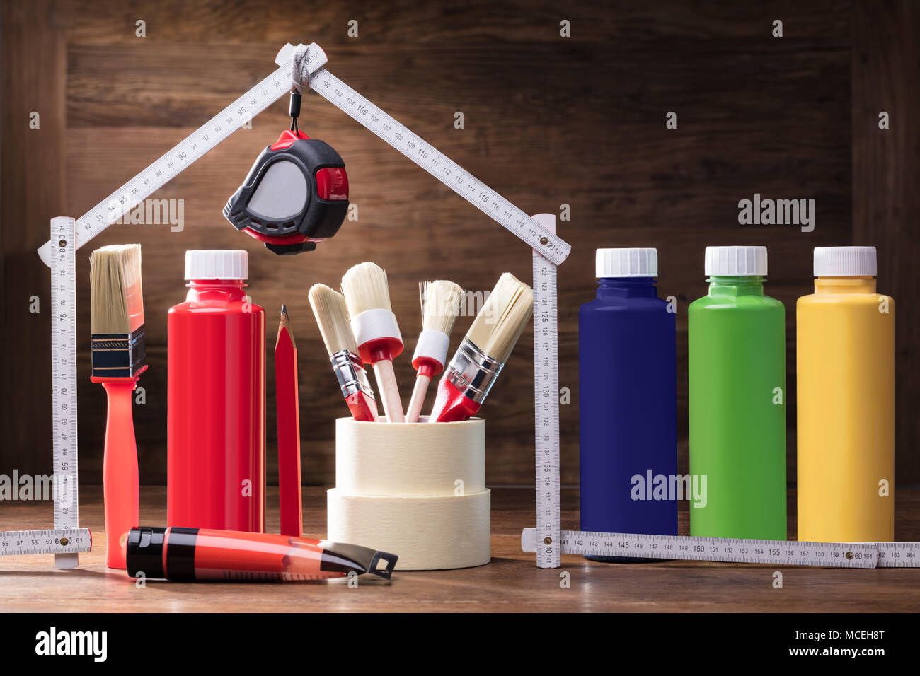 Painting Equipments Under The House Made With Measuring Tape On The Wooden Table Stock Photo