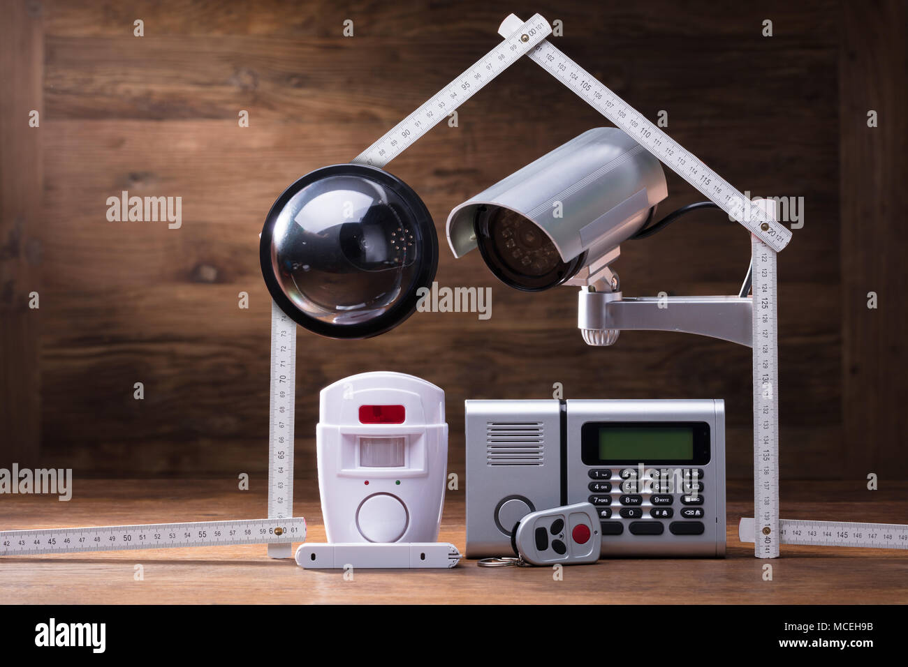 CCTV Camera And Security Alarm System Under The House Made With Measuring Tape Stock Photo