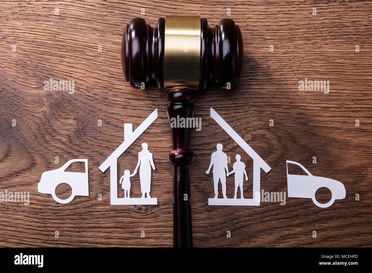 Judge Mallet Between The Split Paper Cutout Family And Car On Wooden Desk Stock Photo