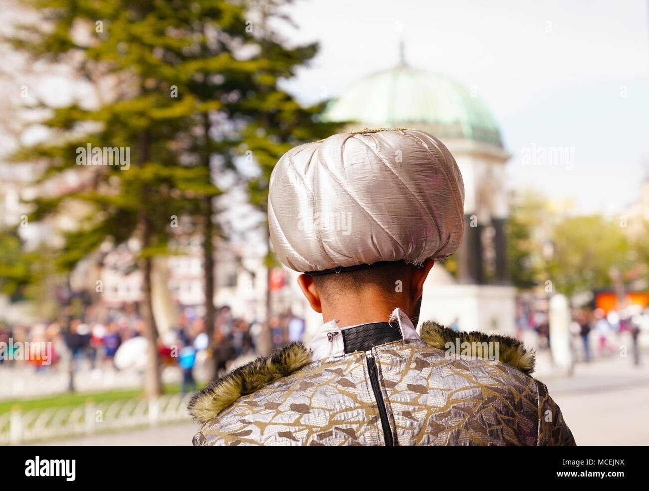 Rear view of a man with sultan's hat and historical building on background in Istanbul Stock Photo
