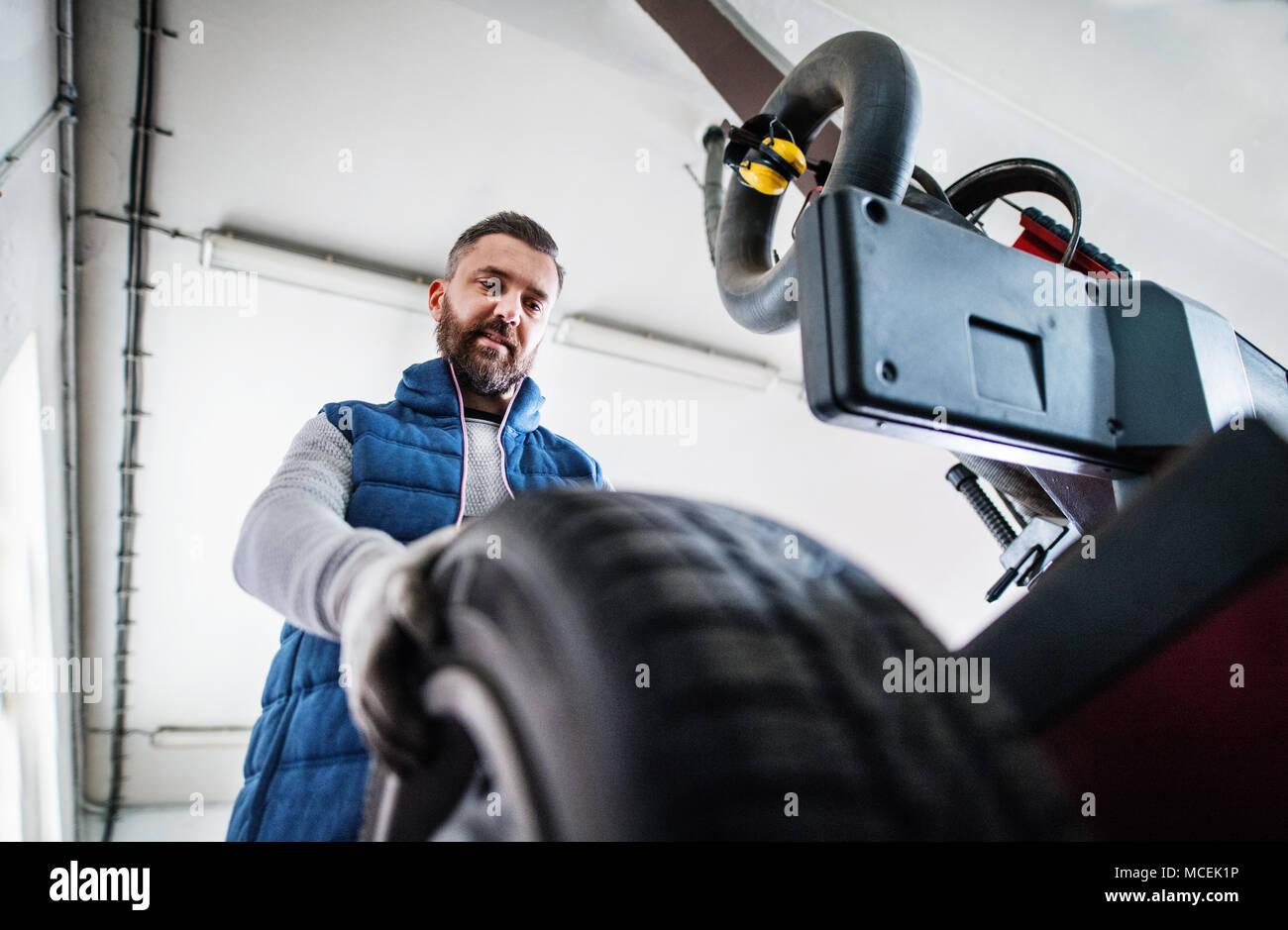 Man mechanic repairing a car in a garage Stock Photo - Alamy