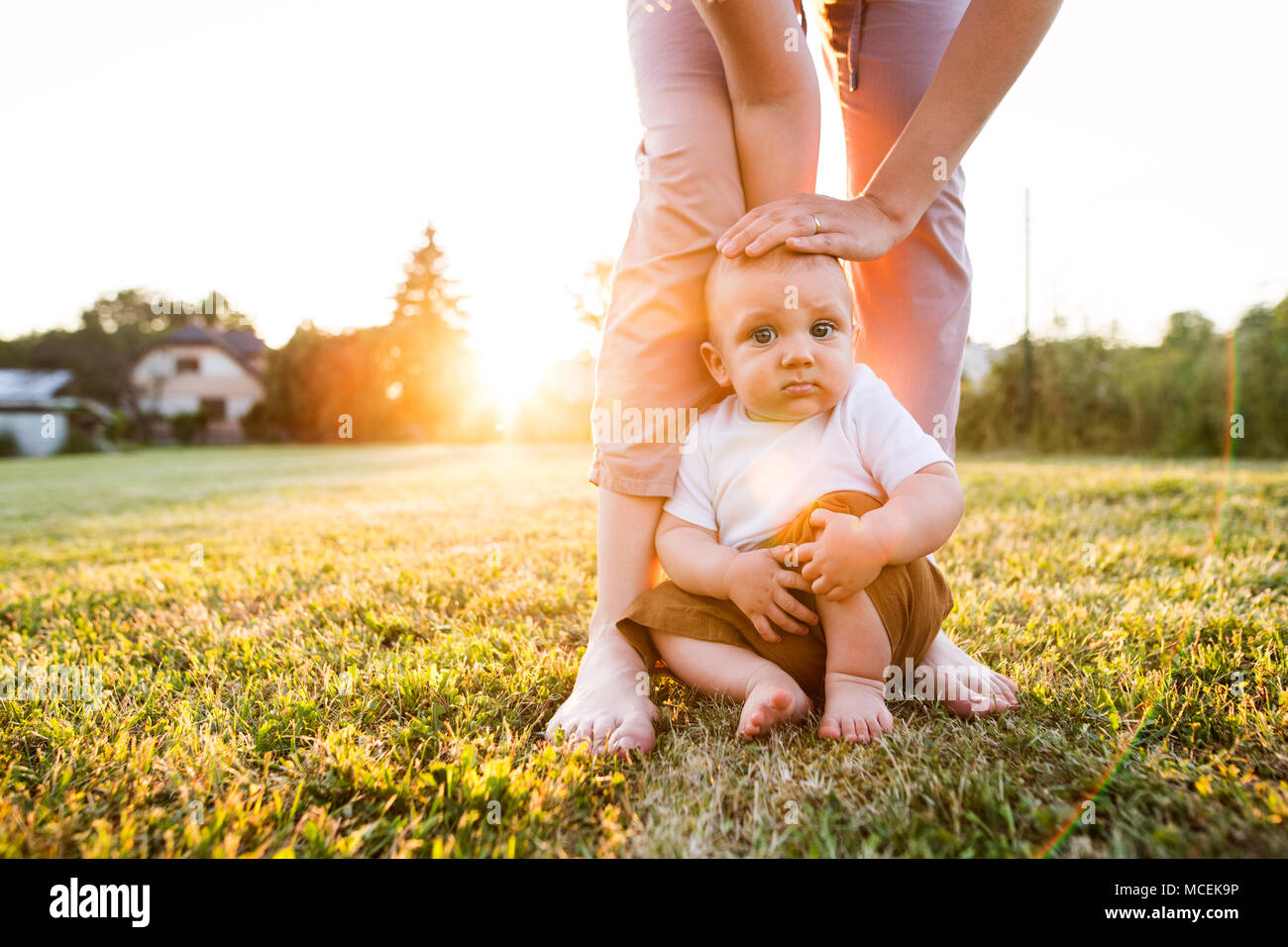 Baby boy with his mother outside in the garden. Stock Photo