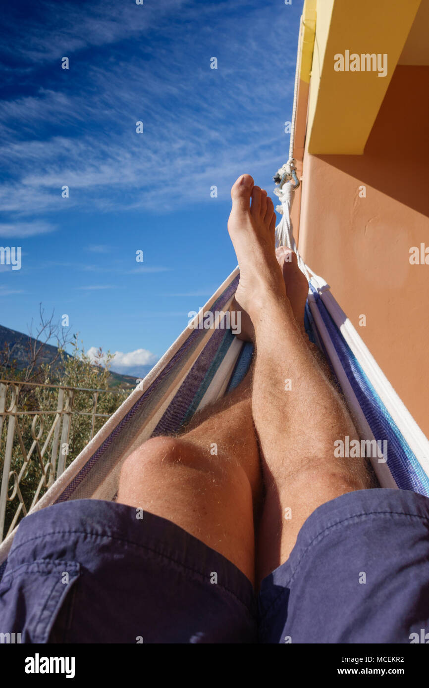 Young man sunbathing and relaxing in hammock, Greece Stock Photo
