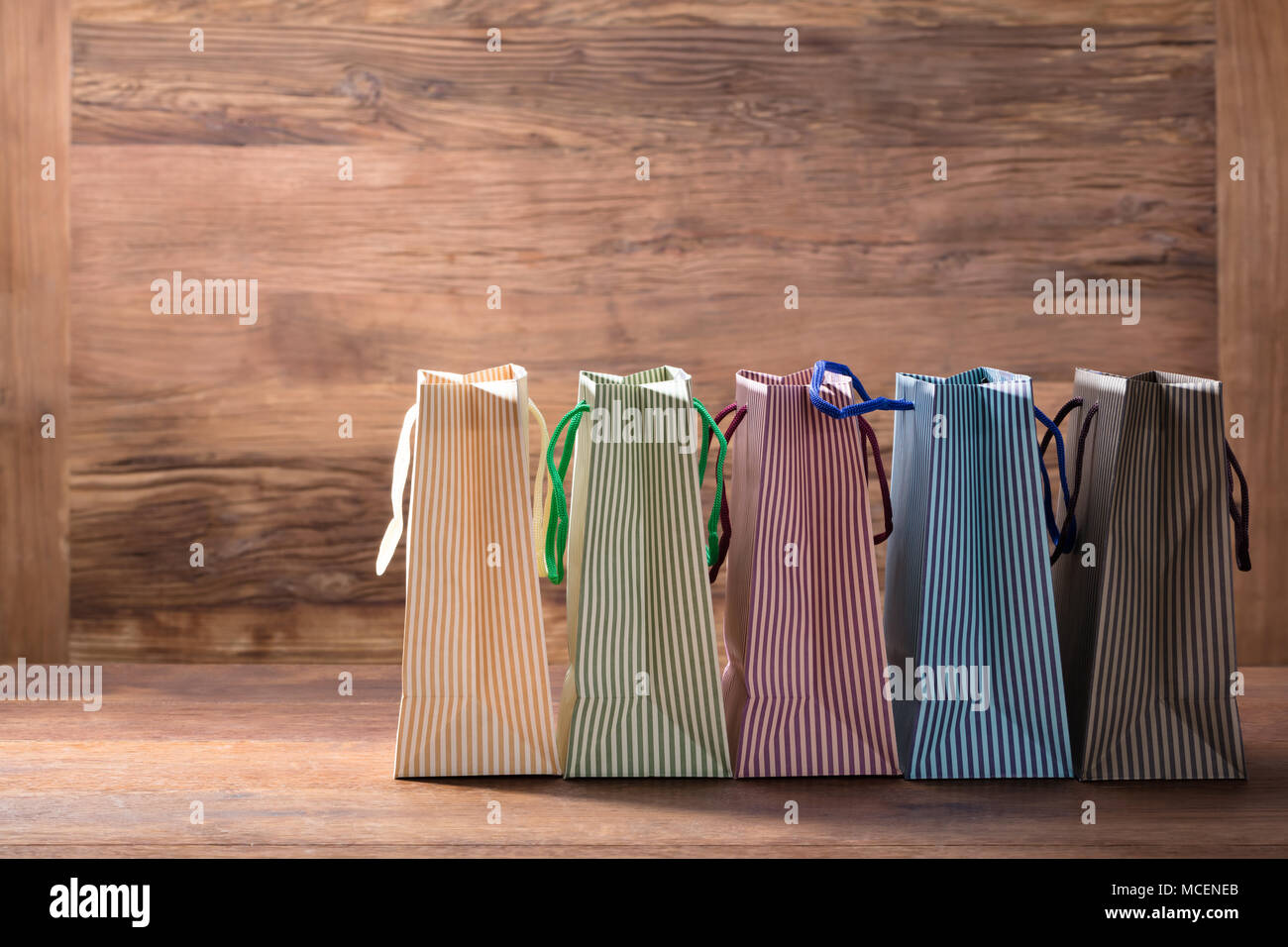 Colorful Striped Shopping Bags In Row On The Wooden Background Stock Photo
