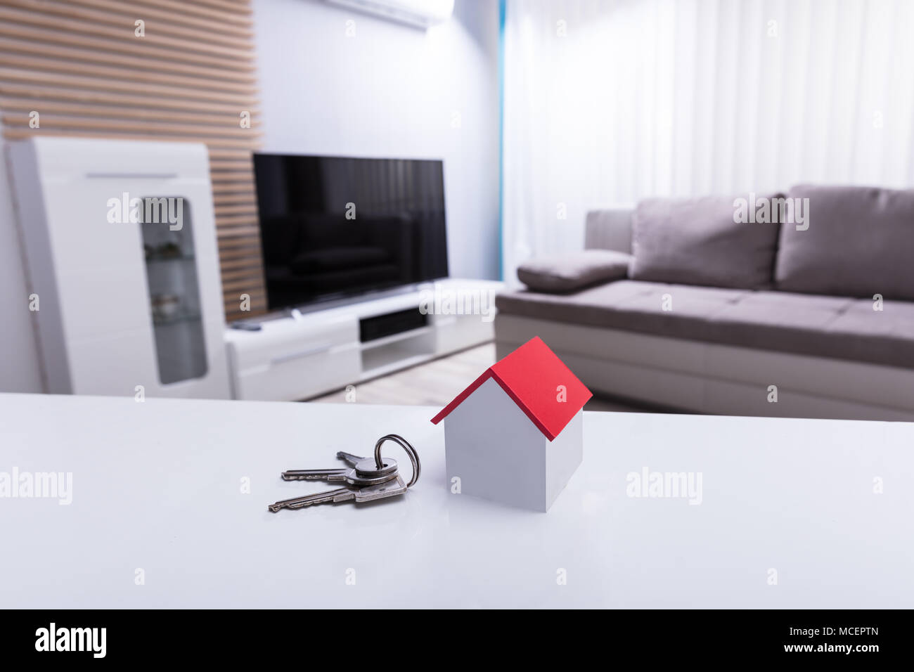 Closeup Of House Model And Key On White Desk In Living Room Stock