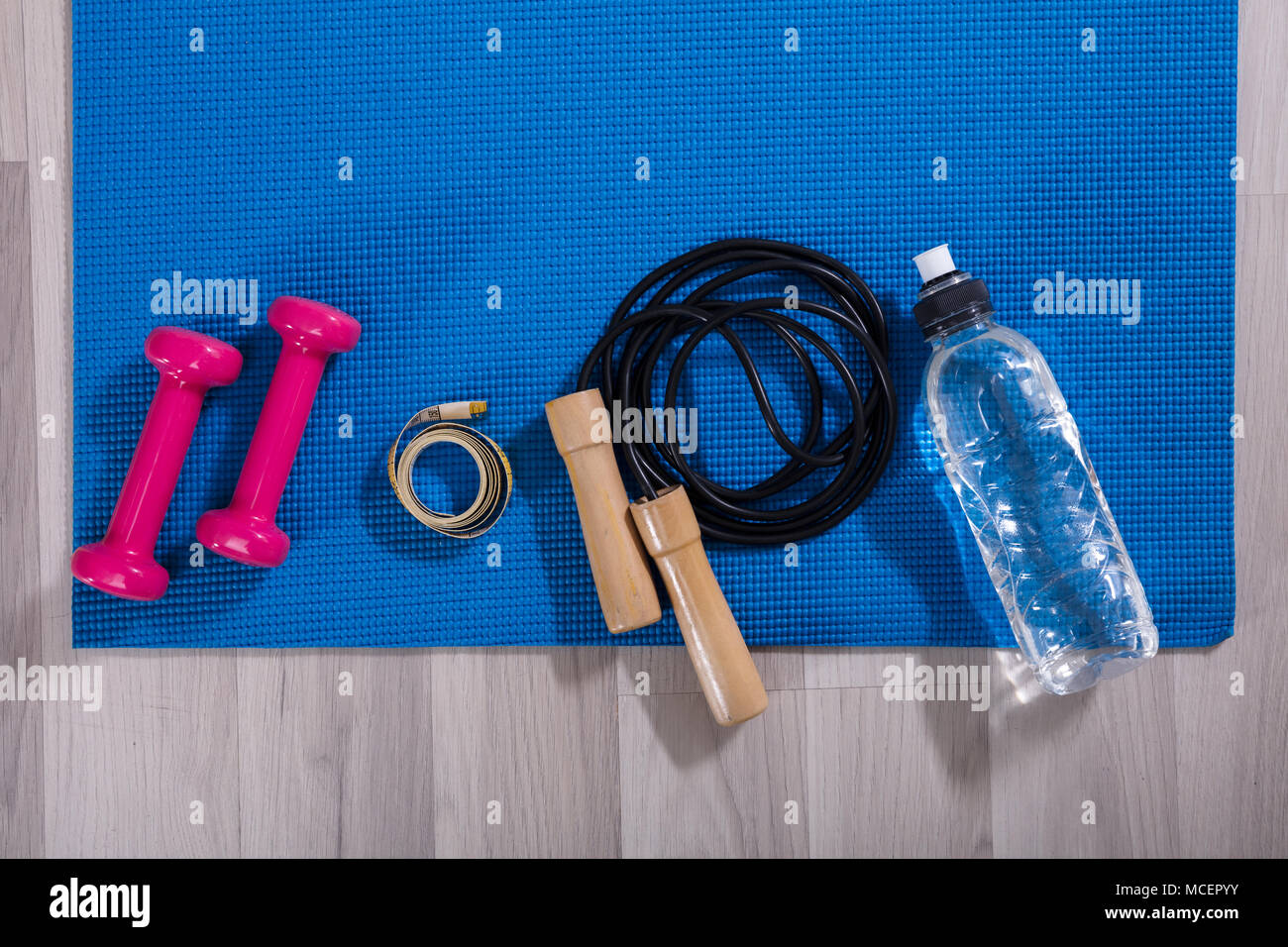 Elevated View Of Fitness Equipments On Blue Exercise Mat Stock Photo