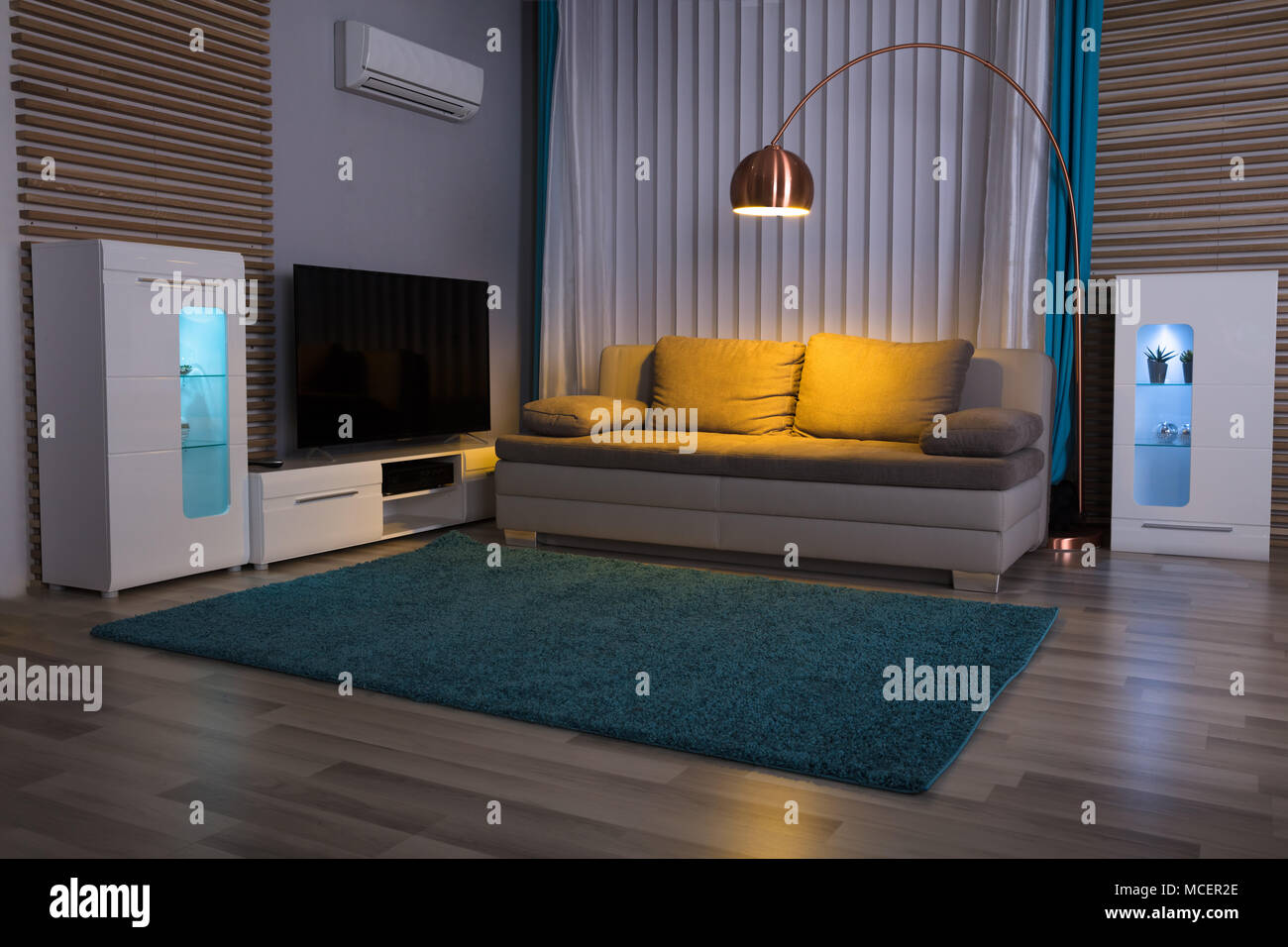 Illuminated Electric Light With Couch And Television In Living Room Stock Photo