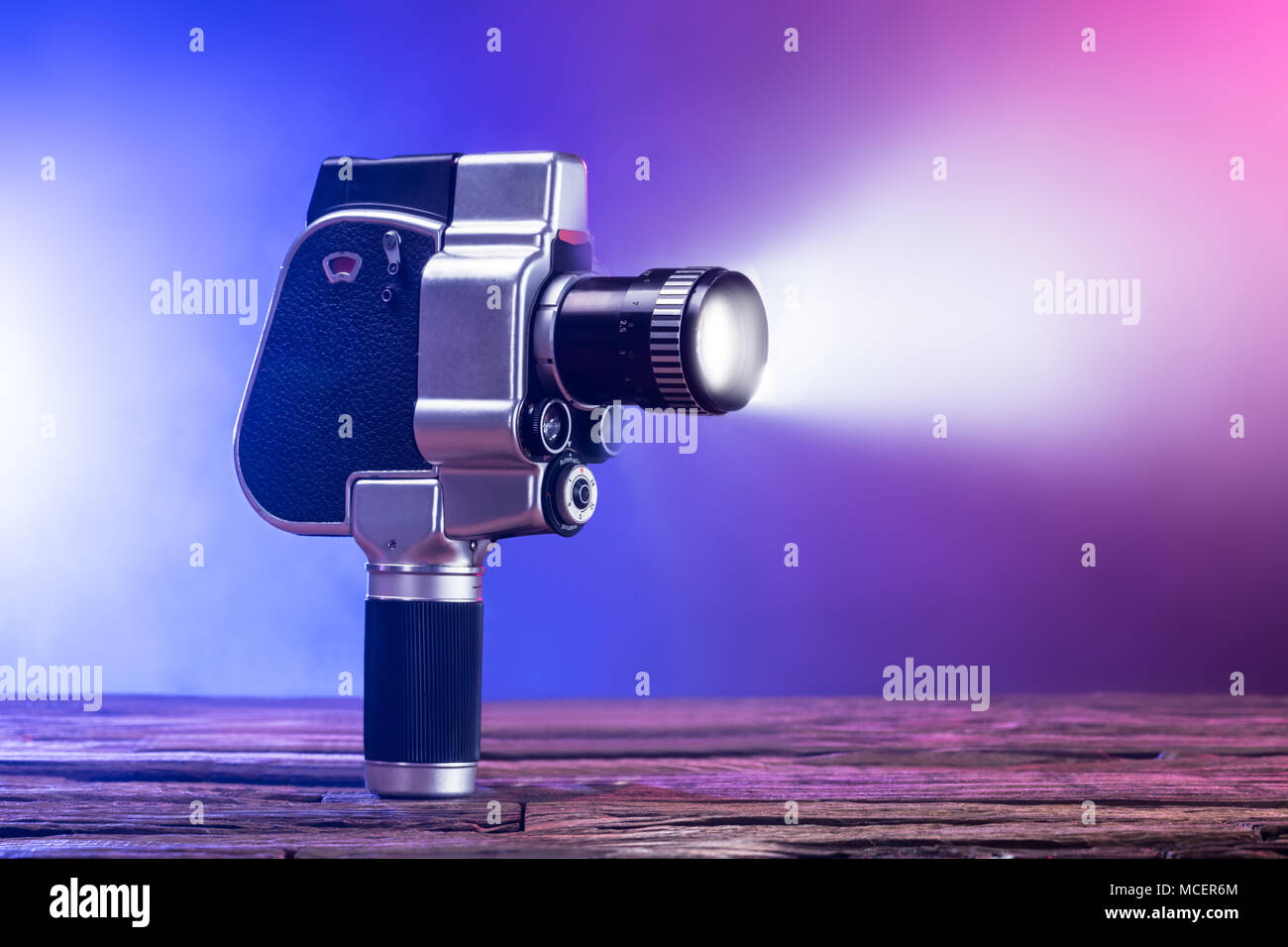 Close-up Of An Illuminated Movie Camera On Wooden Desk Stock Photo