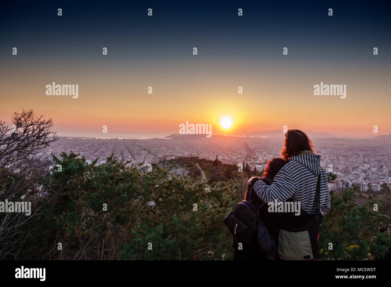 Rear view of couple sightseeing Athens city at sunset, Greece Stock Photo