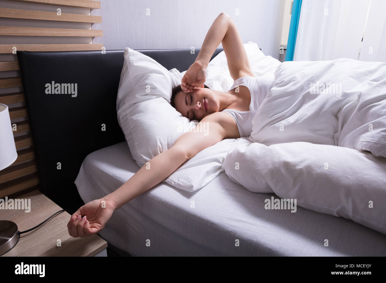 Woman alone in bed and smiling hi-res stock photography and images - Alamy
