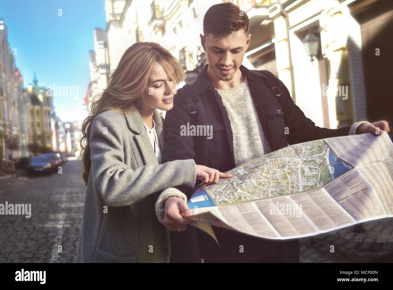 Couple of young tourists reading a map in the city Stock Photo