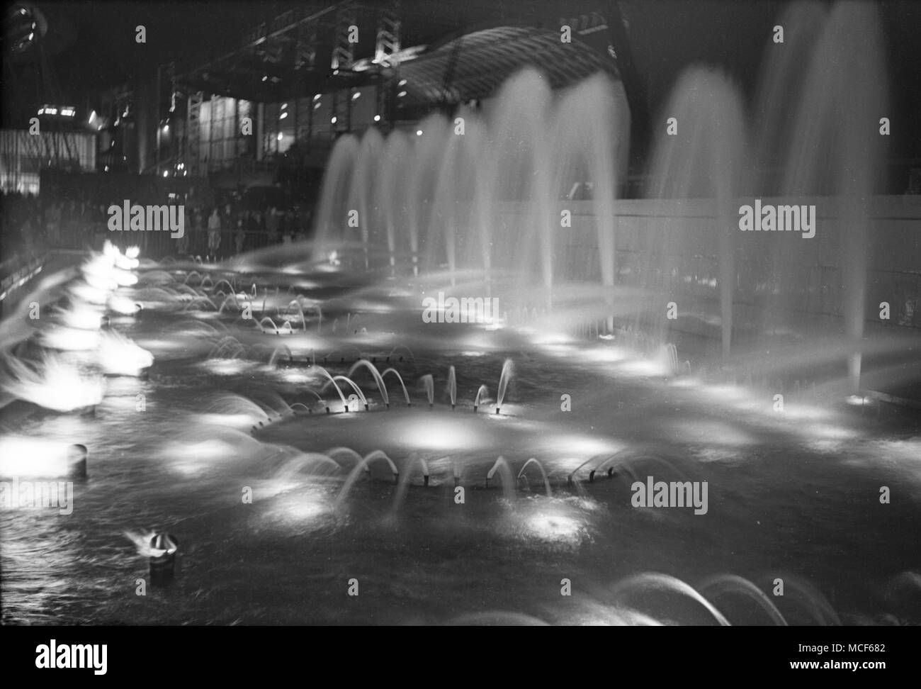 Large pool with multiple fountains, night time, Festival of Britain, London, 1951 Stock Photo