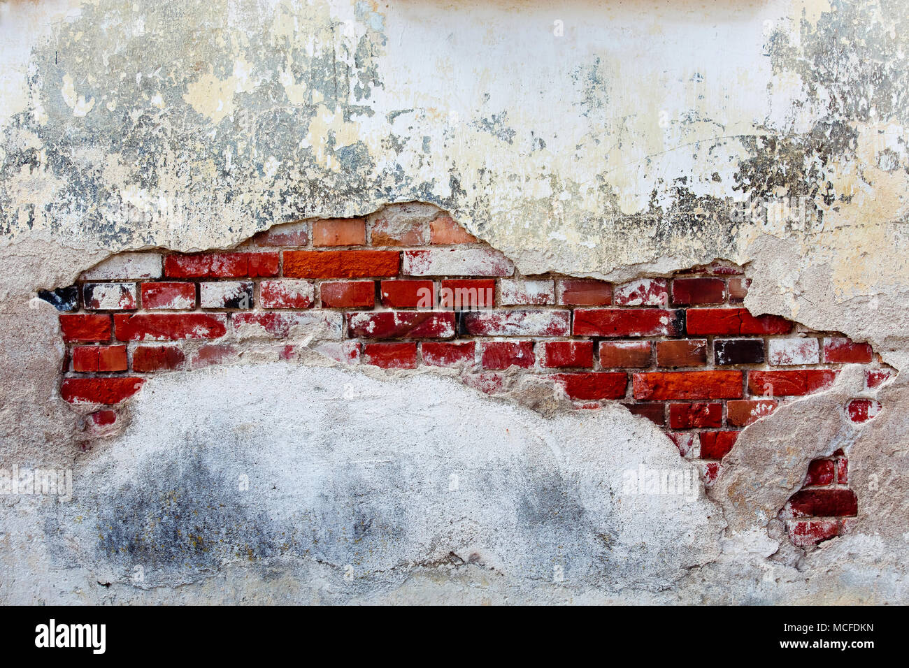Old plastered wall with red bricks Stock Photo