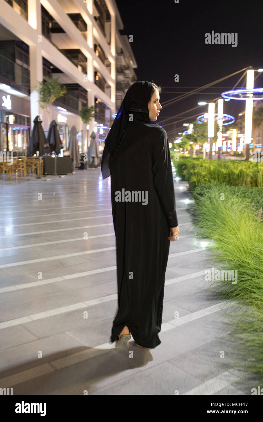 Muslim woman wearing in a hijab walks in the night city Stock Photo - Alamy