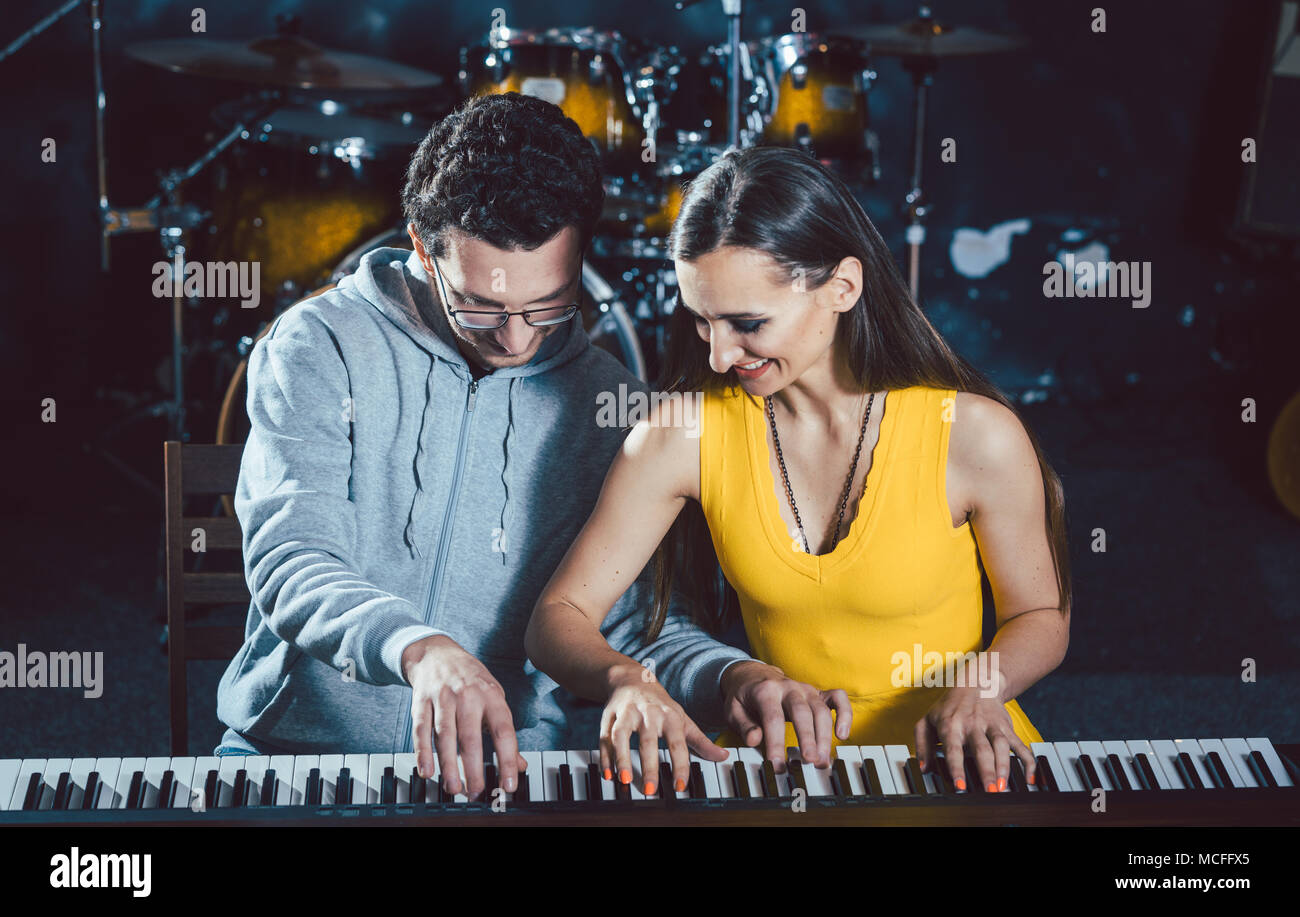Piano teacher giving music lessons to his student Stock Photo