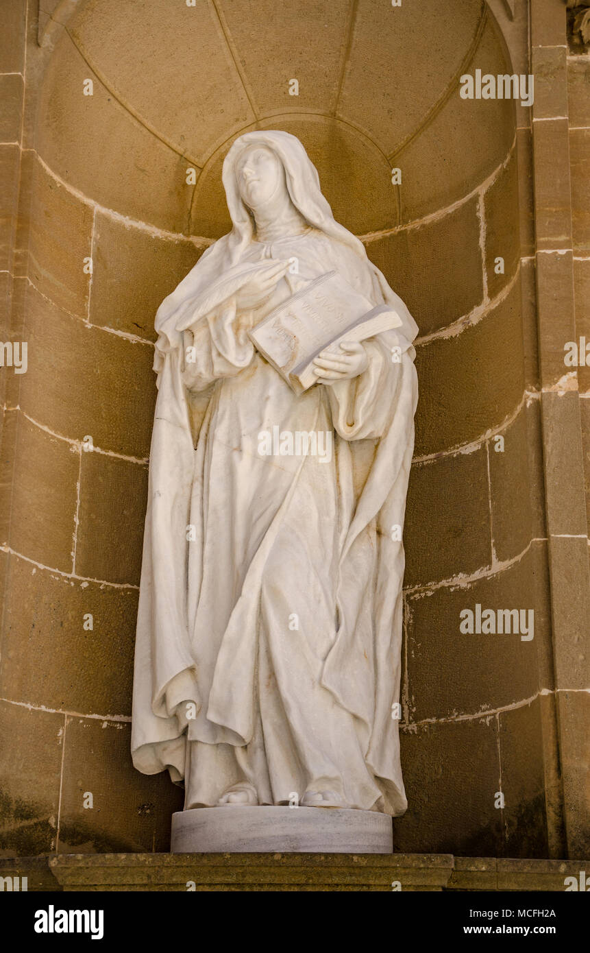 A sculpture depicting the figure of a woman stands in a recessed alcove at Santa Maria de Montserrat Abbey in Spain. Stock Photo