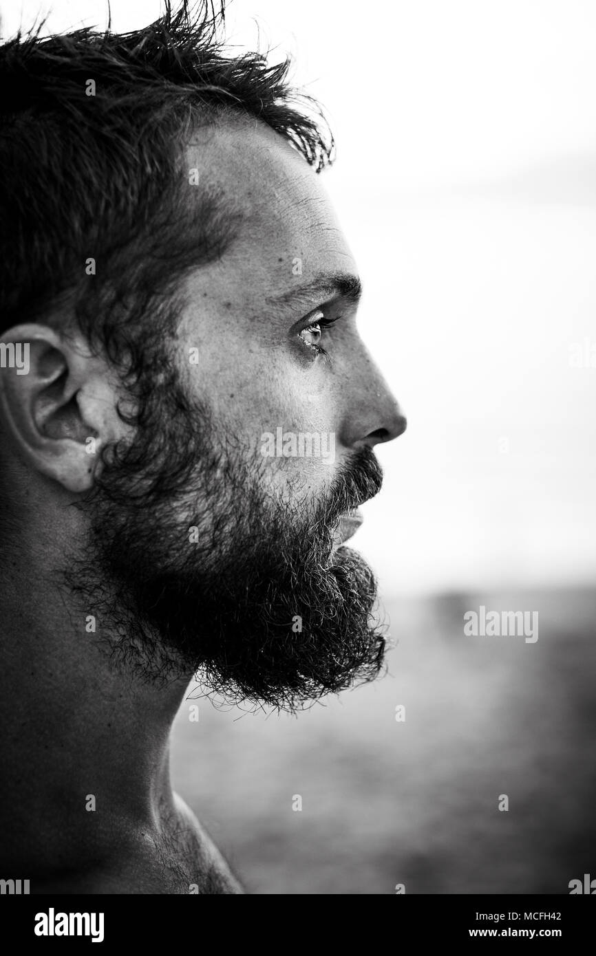 A close up portrait of a bearded surfer at the beach. (minimal focus) Stock Photo
