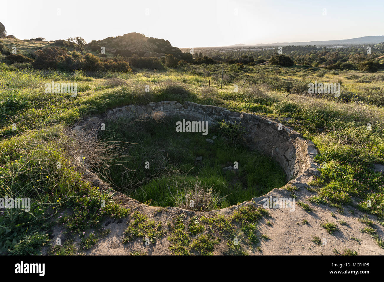 Historic ranch cistern at Santa Susana State Historic Park with the west San Fernando Valley area of Los Angeles, California in background. Stock Photo