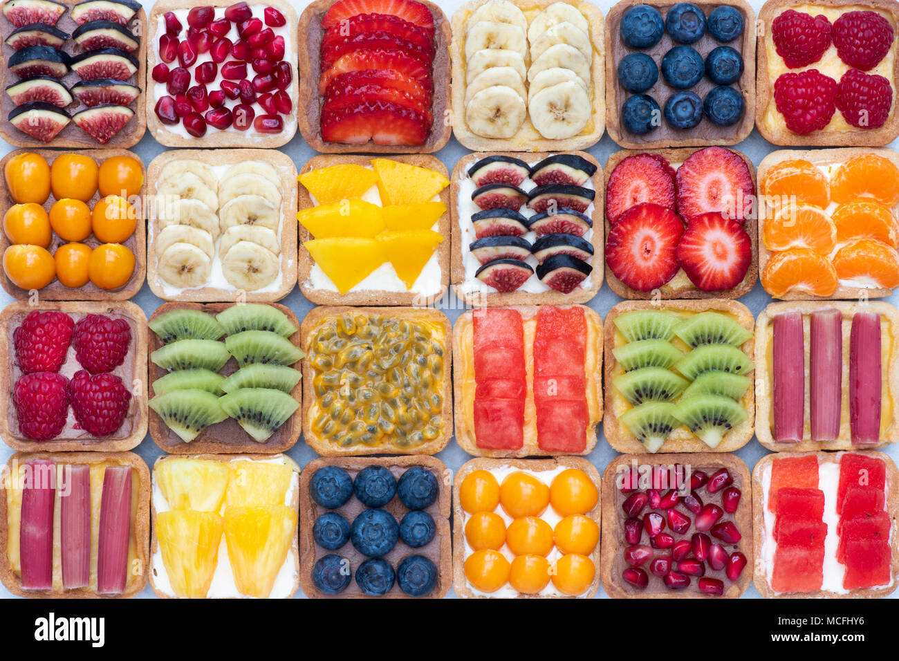 Colourful square fruit tarts on a white background Stock Photo