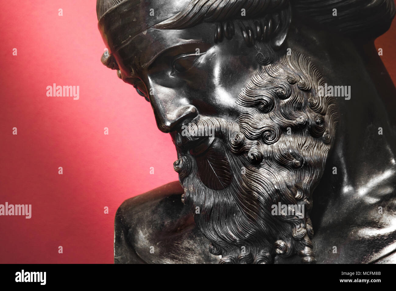 Black statue of bearded man face portrait red background Stock Photo