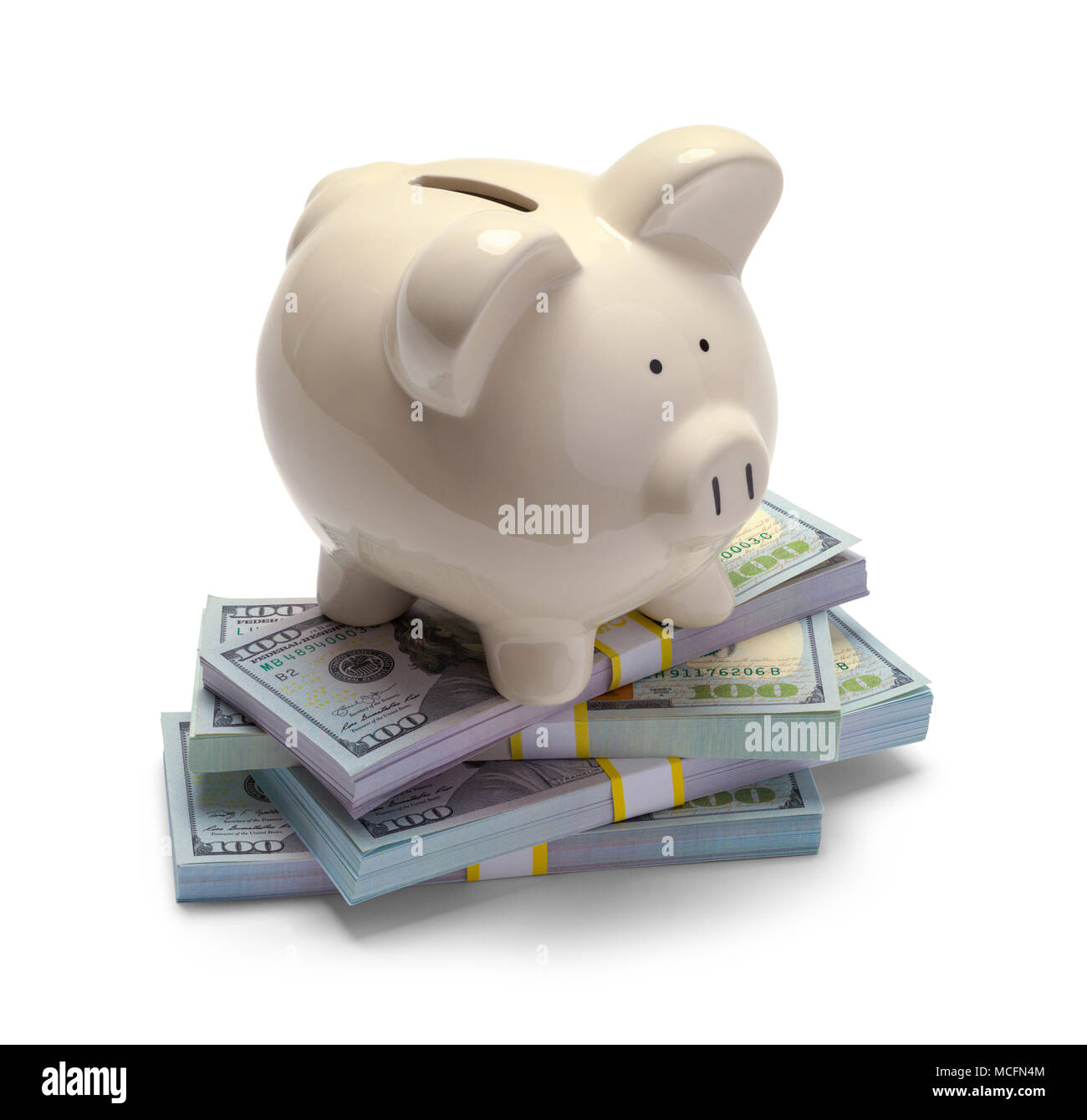 Pile of Money with a Piggy Bank on Top Isolated on a White Background. Stock Photo