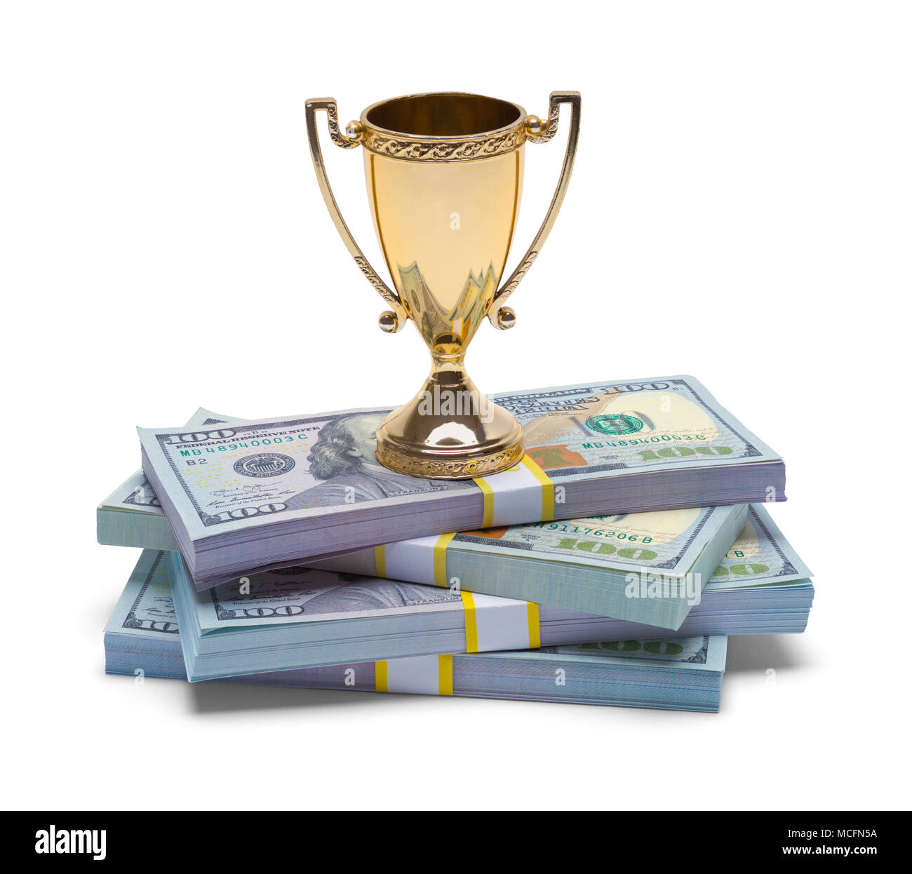 Pile of Money with a Gold Trophy Cup Isolated on a White Background. Stock Photo