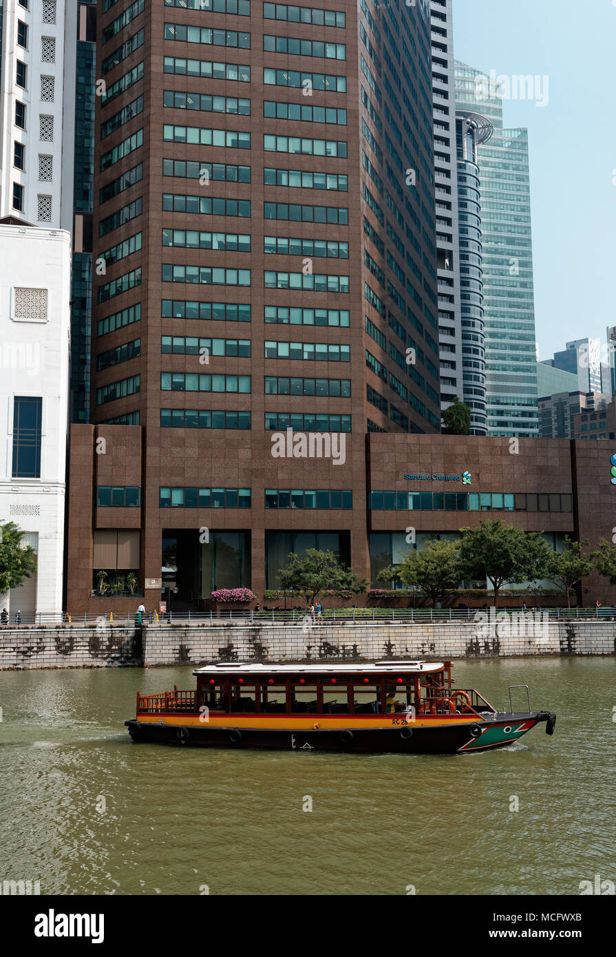 tour boat on the Singapore River passing the business district before Boat Quay Stock Photo