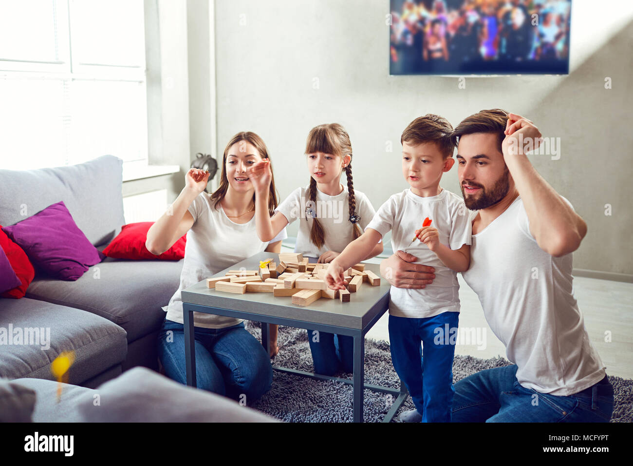 Happy family playing board games at home. Mother, father and children play together. Stock Photo