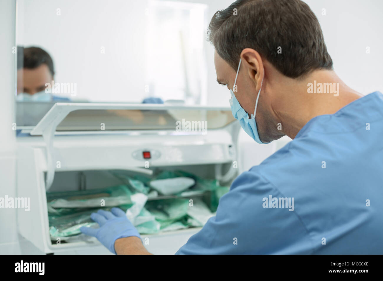 Professional male dentist sterilizing instruments Stock Photo